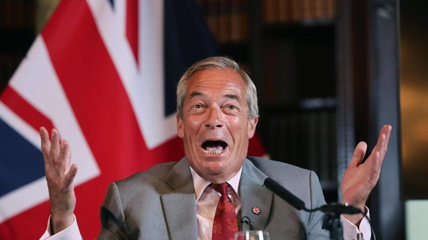 Nigel Farage gesticulando sonriente en una conferencia de prensa tras anunciar su candidatura en Clacton.