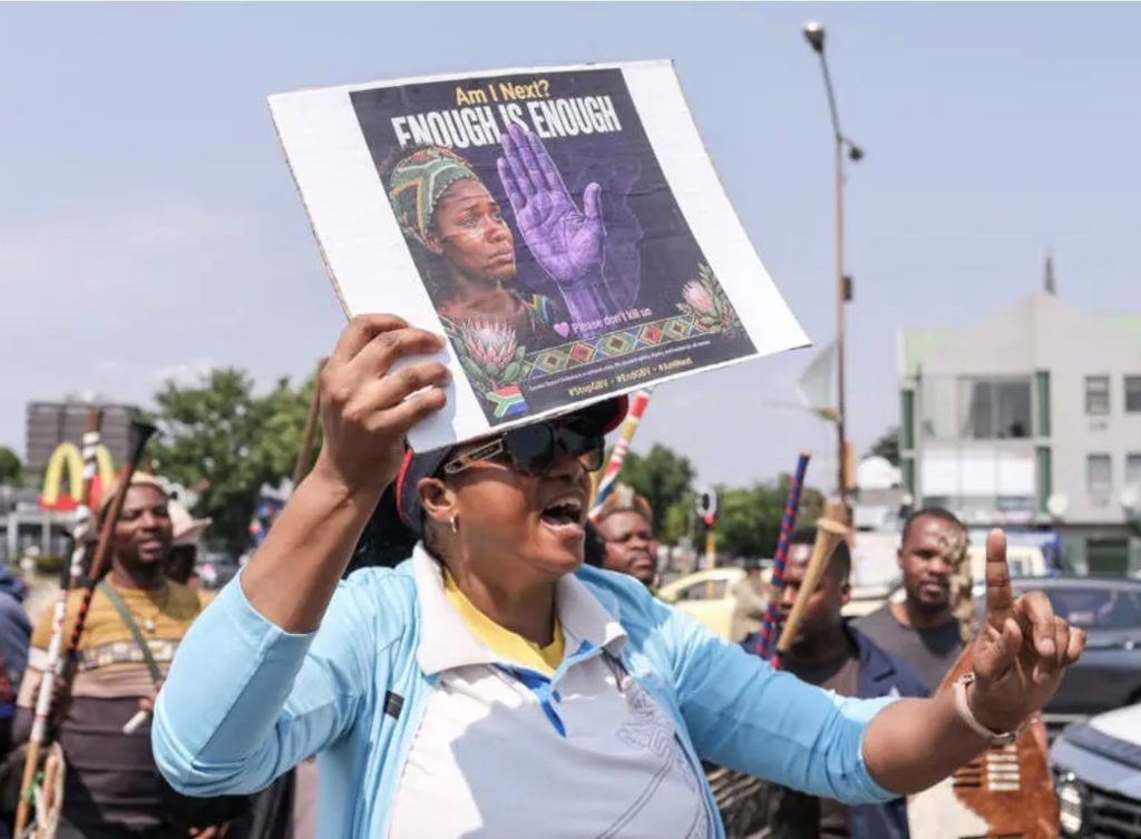 Una mujer sostiene un cartel mientras participa junto con otras personas en una marcha de protesta en Kempton Park el 19 de septiembre de 2026, a raíz de la reciente serie de asesinatos ocurridos en el este de Johannesburgo, en Sudáfrica. © MZINGENKOSI SIBANDA / AFP